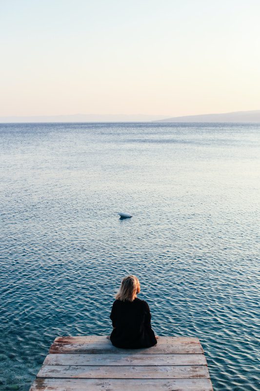 person on end of jetty looking out to sea