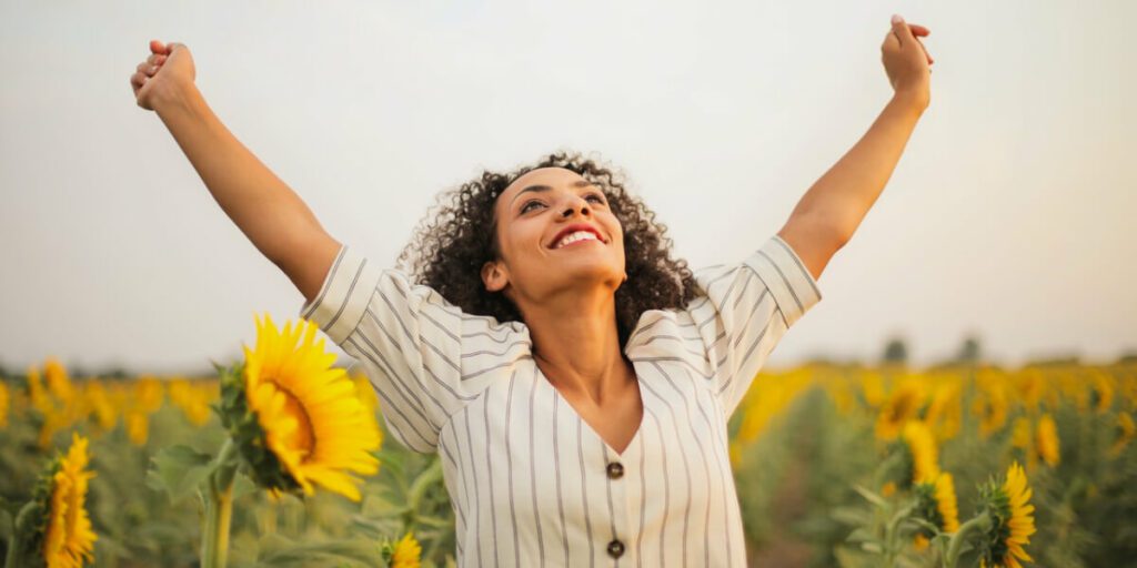celebratory woman in sunflower field